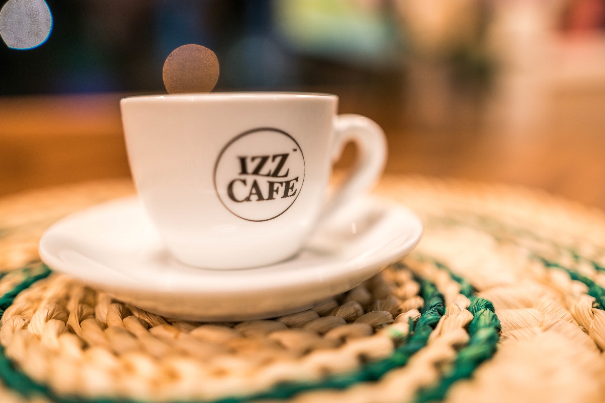 Izz Cafe coffee cup with a saucer